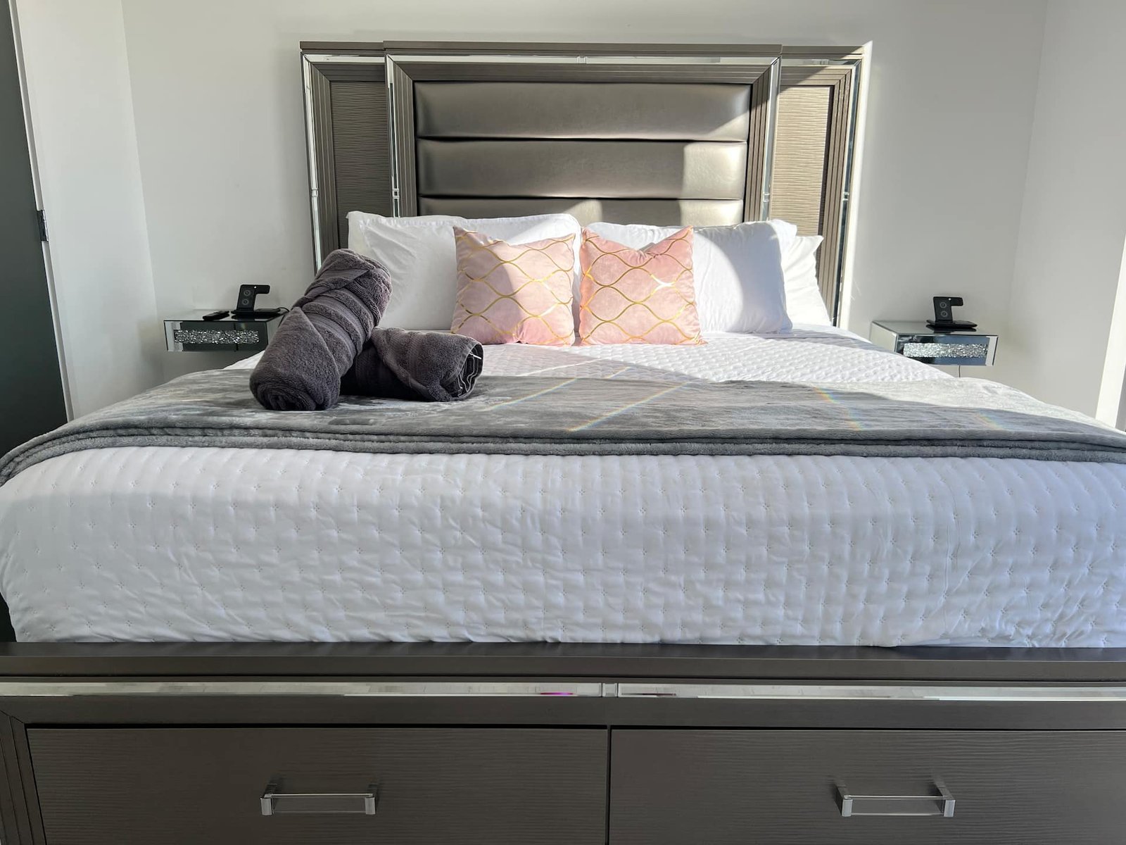 King bedroom with mirrored headboard and plush linens