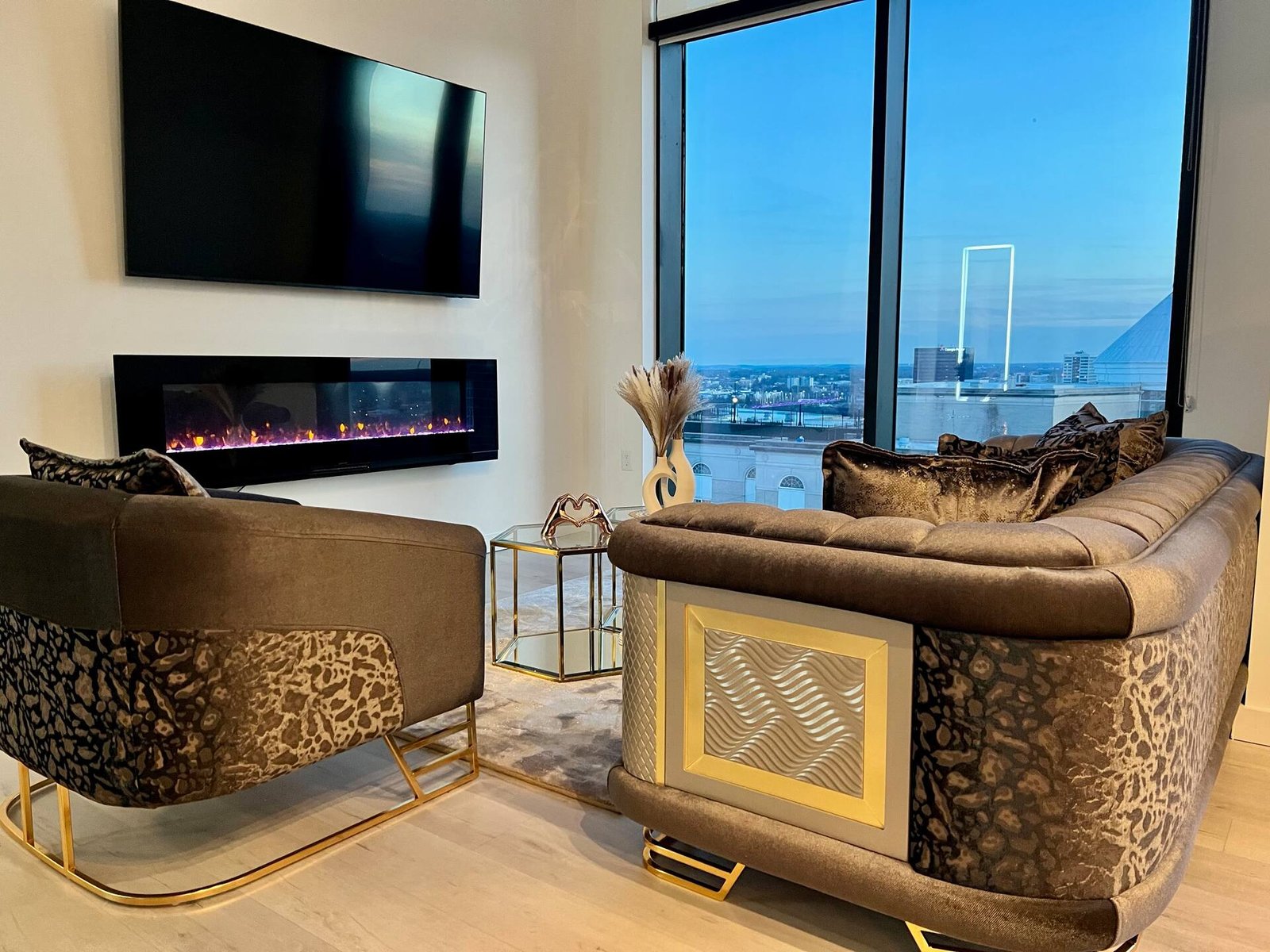Lounge with linear fireplace, gold accents and city view