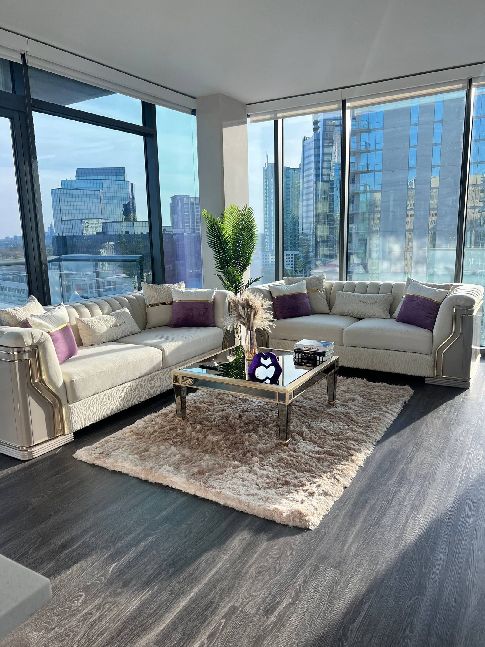 Living room with cream sofas and wraparound city windows