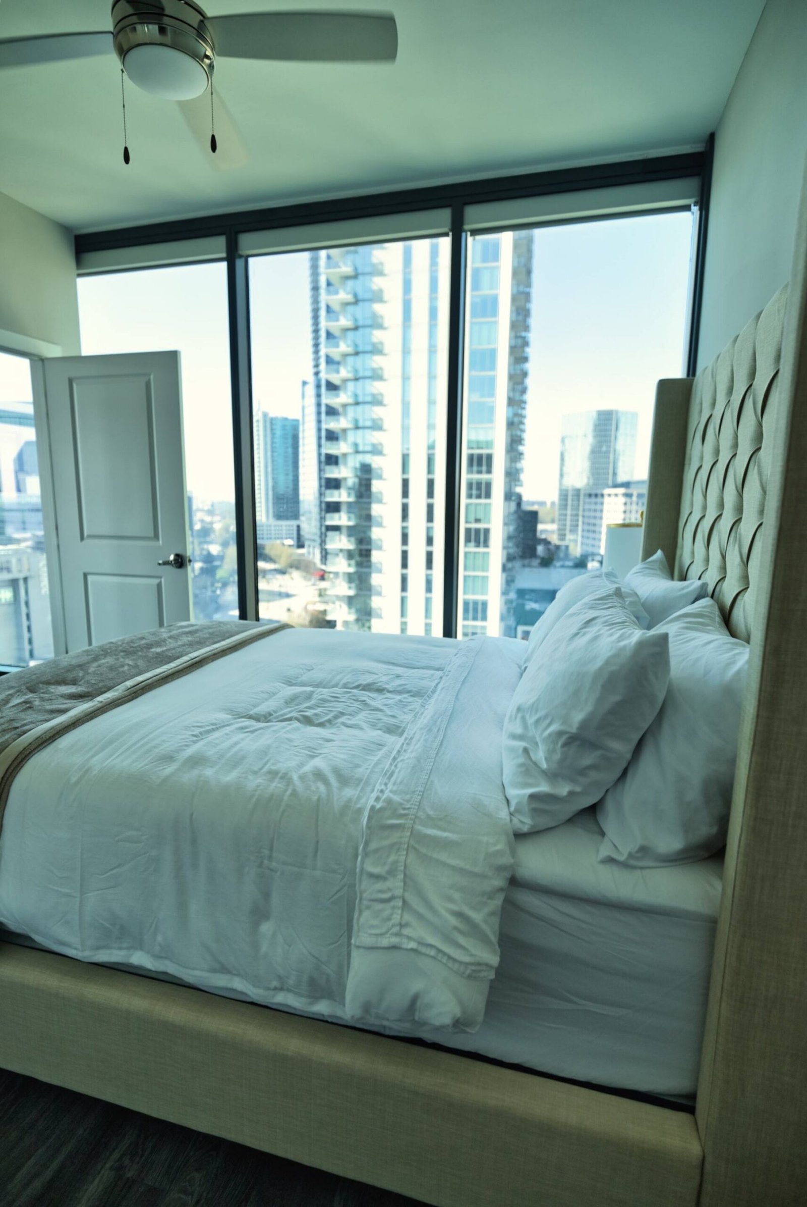 Bedroom with tufted headboard and skyline outlook