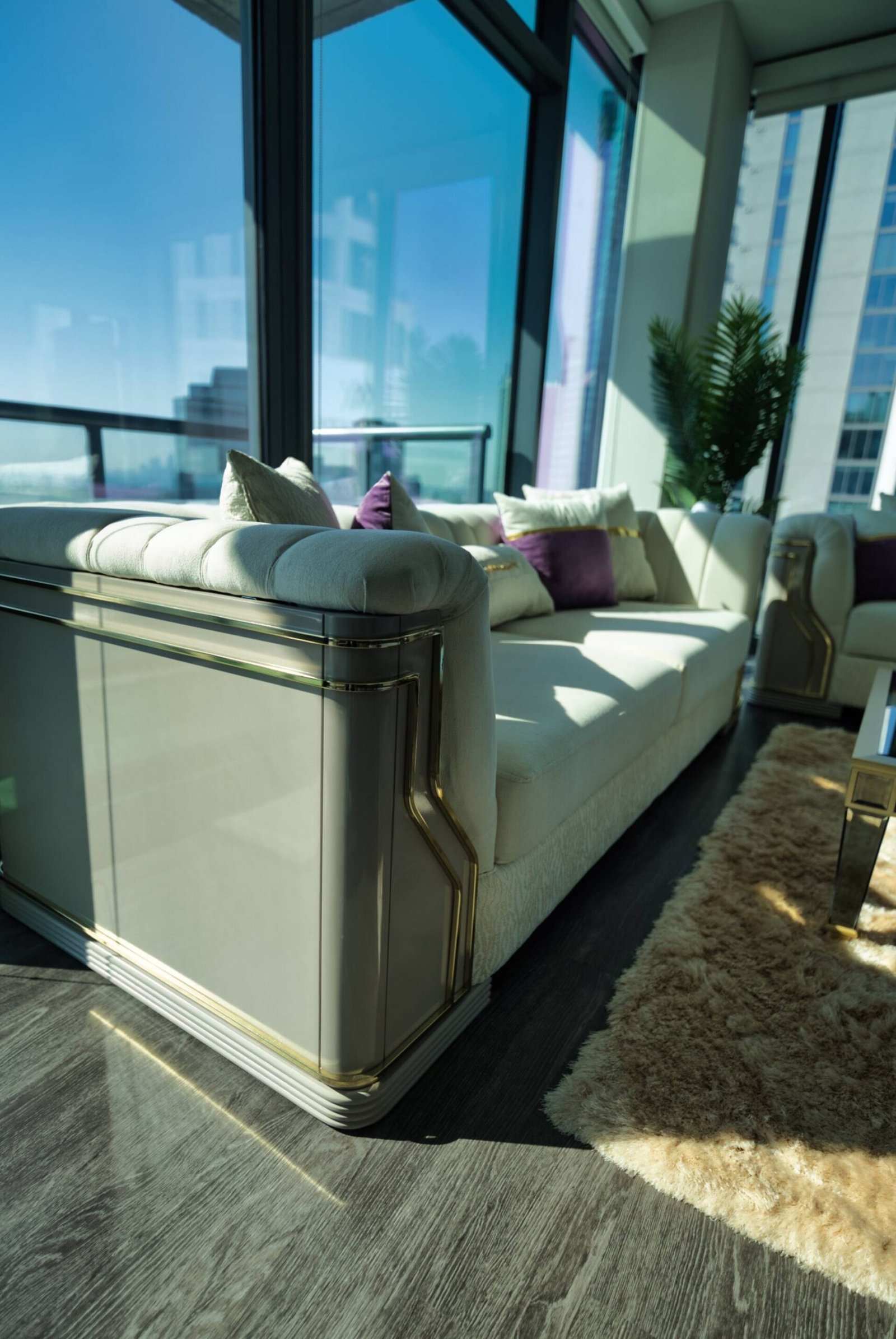 Designer sofa and mirrored console beside the windows
