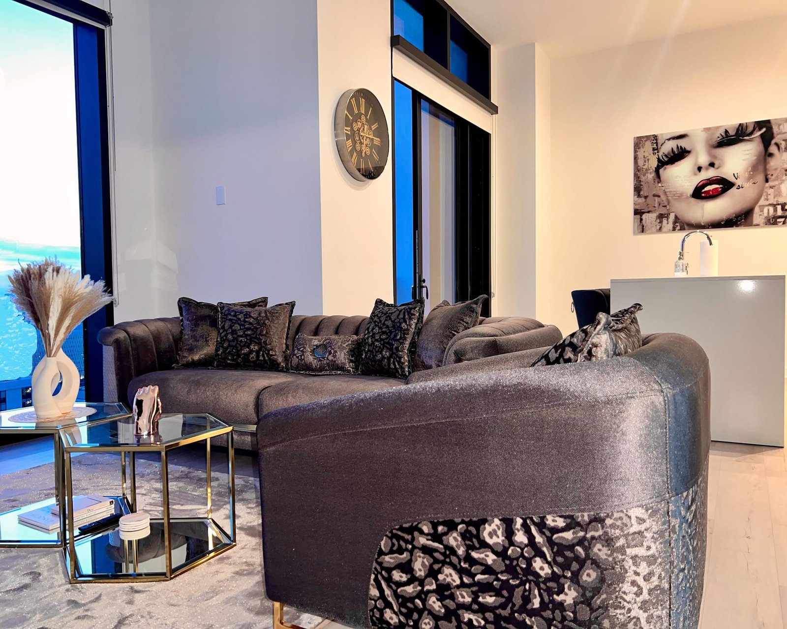 Penthouse living room with velvet sectional and skyline windows